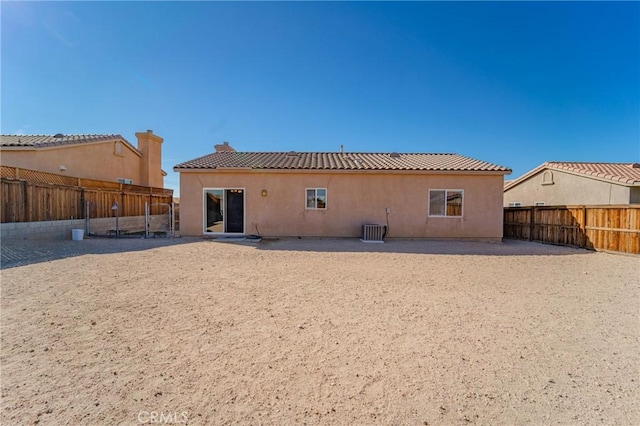 back of house featuring stucco siding, a fenced backyard, cooling unit, and a chimney