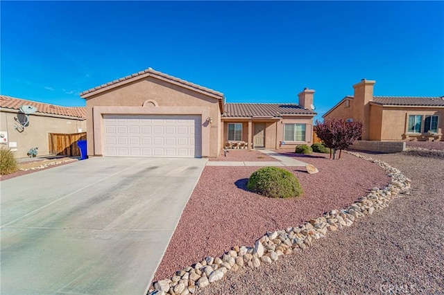 view of front of house featuring a garage, driveway, stucco siding, a tiled roof, and a chimney