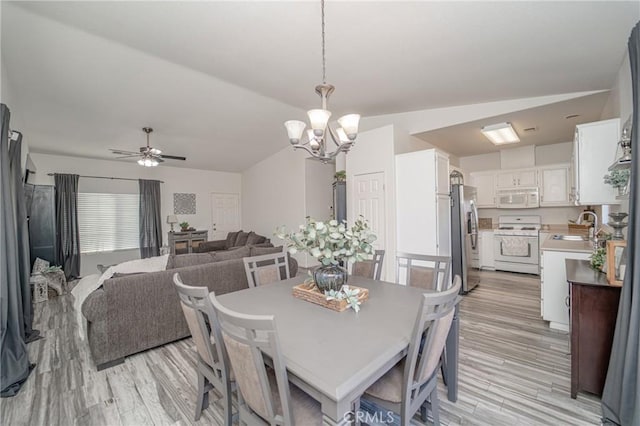 dining area featuring a chandelier, light wood finished floors, ceiling fan, and lofted ceiling
