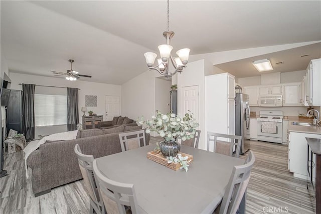 dining room with a chandelier, light wood finished floors, and a ceiling fan