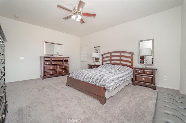 bedroom with light colored carpet, a ceiling fan, and baseboards