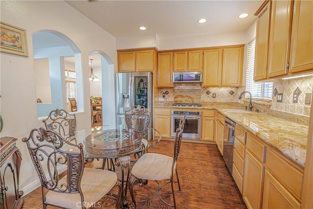 24472 Montevista Cir, Valencia, CA 91354 - kitchen featuring stainless steel appliances, a sink, light brown cabinets, arched walkways, and wood finished floors