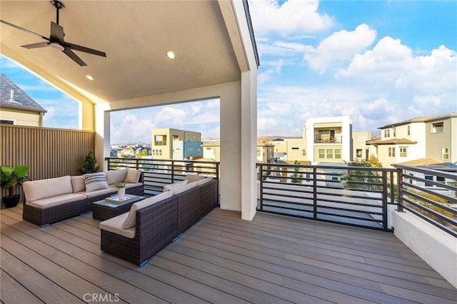 wooden terrace with outdoor lounge area, a ceiling fan, and a residential view