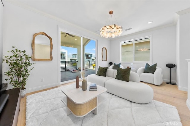 living area featuring ornamental molding, light wood-style floors, baseboards, a chandelier, and recessed lighting