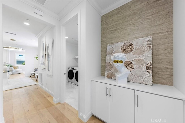 hallway with crown molding, an accent wall, recessed lighting, light wood finished floors, and independent washer and dryer