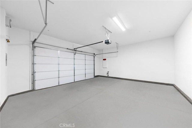 garage featuring a garage door opener and baseboards