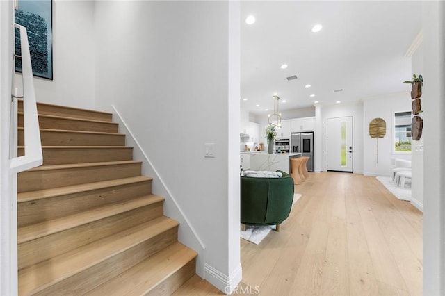 staircase with recessed lighting, wood finished floors, and baseboards