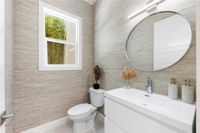 bathroom featuring toilet, vanity, and tile walls