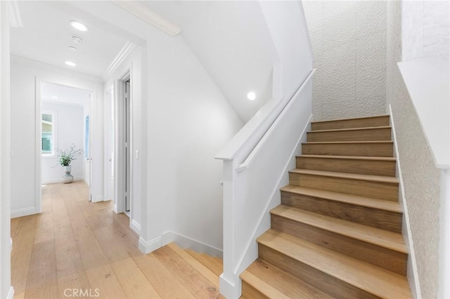 staircase featuring ornamental molding, wood-type flooring, recessed lighting, and baseboards