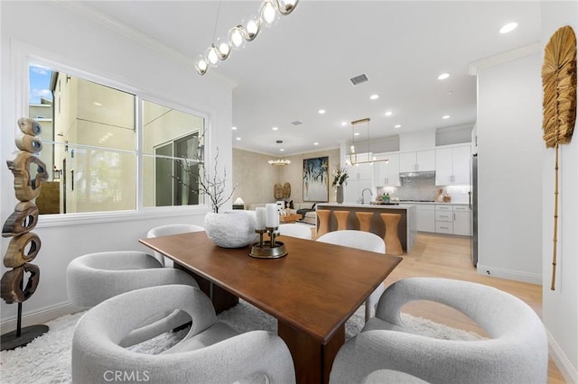 dining area featuring crown molding, baseboards, recessed lighting, and light wood-style flooring