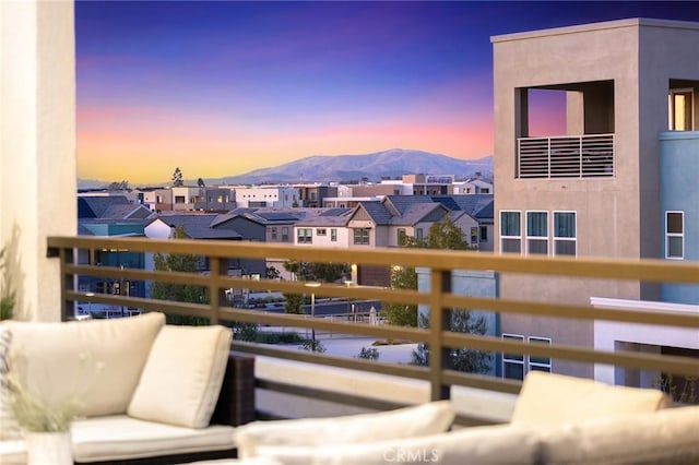 balcony at dusk with a mountain view and a residential view