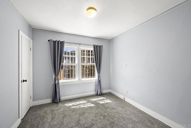 carpeted spare room with baseboards and crown molding