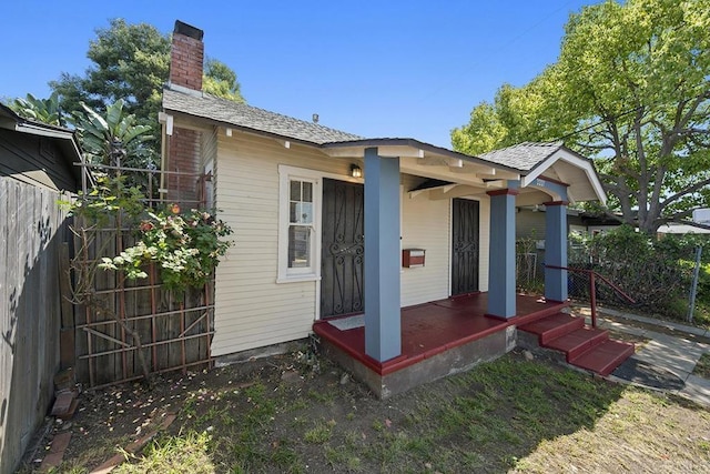 back of property with fence and a chimney