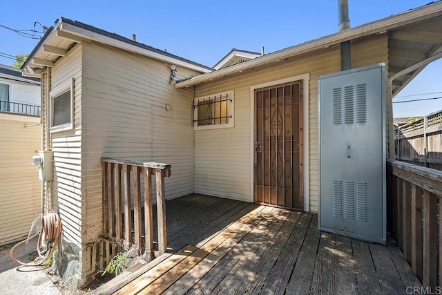 doorway to property with a wooden deck and fence