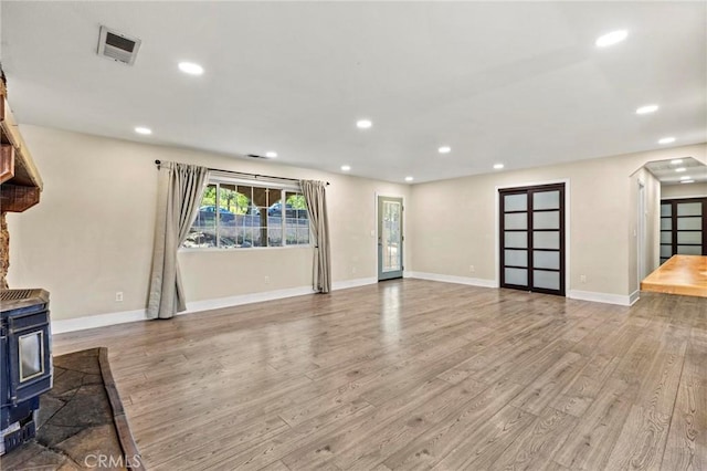 2681 Pinecrest Rd, Oroville, CA 95966 - unfurnished living room with a wood stove, wood finished floors, recessed lighting, arched walkways, and baseboards