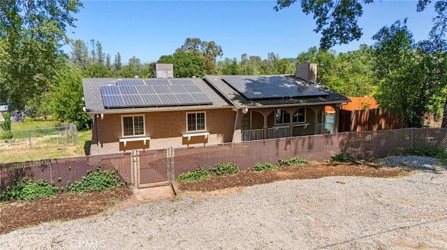 2681 Pinecrest Rd, Oroville, CA 95966 - view of front of property with a chimney, roof mounted solar panels, covered porch, a gate, and a fenced front yard