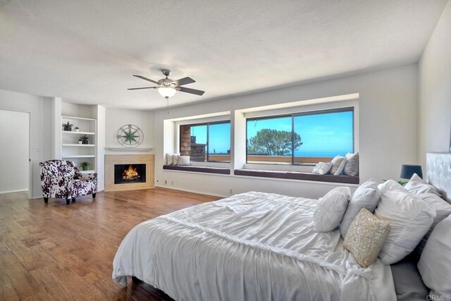 13063 Caminito Del Rocio, Del Mar, CA 92014 - bedroom featuring wood finished floors, ceiling fan, and a fireplace with flush hearth