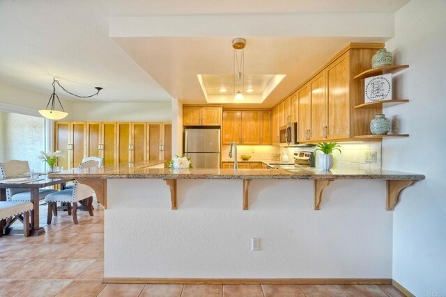 13063 Caminito Del Rocio, Del Mar, CA 92014 - kitchen with stainless steel appliances, open shelves, light stone counters, a peninsula, and hanging light fixtures