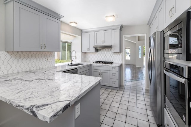30602 Colina Verde St, Temecula, CA 92592 - kitchen featuring stainless steel appliances, a sink, a peninsula, gray cabinets, and backsplash