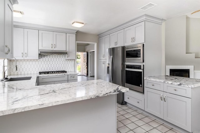 30602 Colina Verde St, Temecula, CA 92592 - kitchen with appliances with stainless steel finishes, a peninsula, a sink, and decorative backsplash