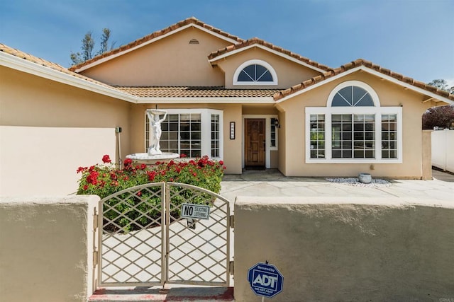 30602 Colina Verde St, Temecula, CA 92592 - view of exterior entry featuring fence, a gate, stucco siding, and a tiled roof