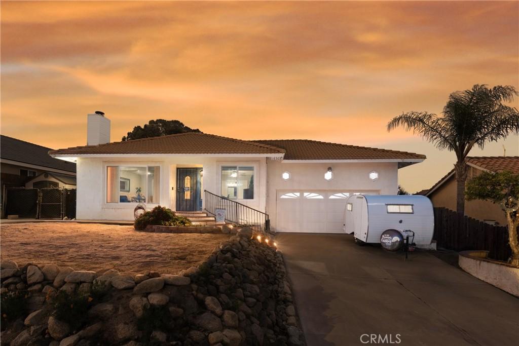 16503 Mountain St, Lake Elsinore, CA 92530 - view of front of house with a tiled roof, an attached garage, driveway, a chimney, and fence