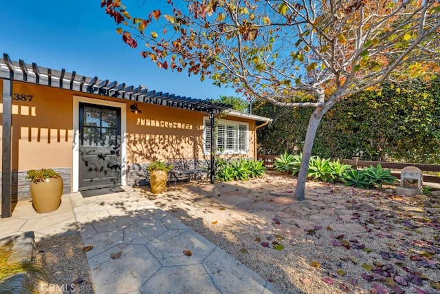 view of exterior entry featuring a patio area and stucco siding