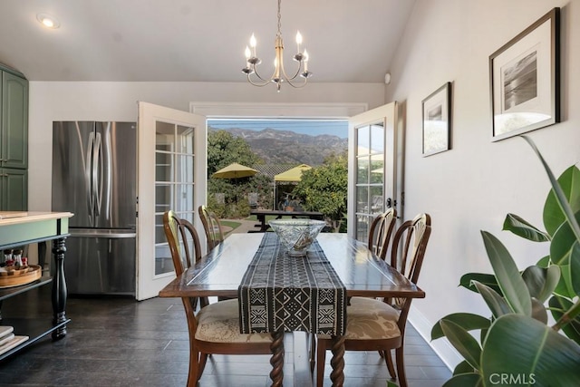 dining area featuring dark wood-style floors, a chandelier, lofted ceiling, and baseboards