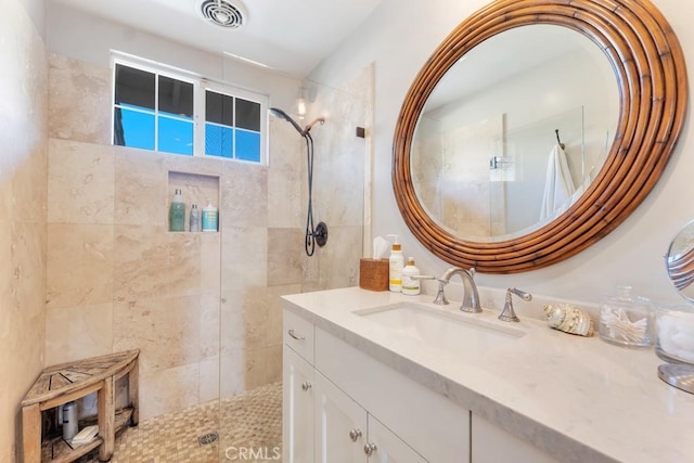 bathroom featuring a tile shower and vanity