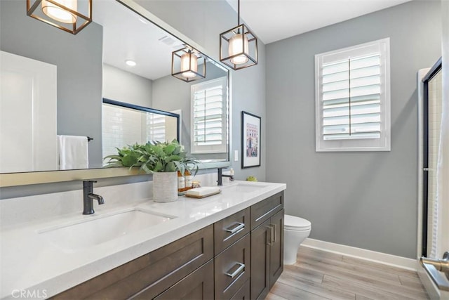 1772 Lundy Ln, Beaumont, CA 92223 - full bath with wood finished floors, baseboards, a shower stall, toilet, and double vanity
