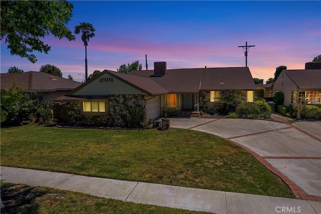 15142 Tuba St, San Fernando, CA 91345 - ranch-style house with stone siding, a garage, driveway, and a lawn