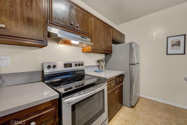 kitchen featuring stainless steel appliances, under cabinet range hood, baseboards, and light countertops