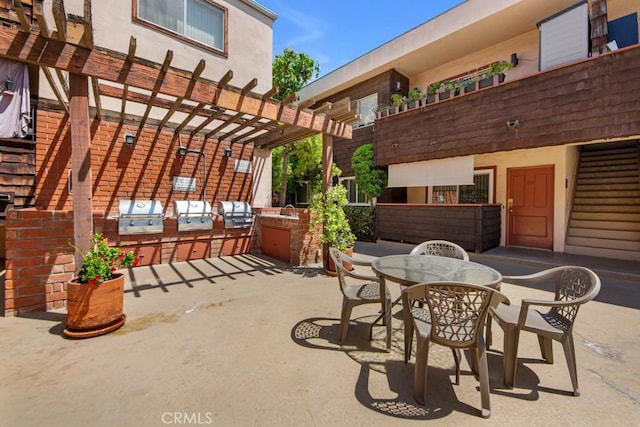 view of patio with exterior kitchen, a pergola, area for grilling, and outdoor dining area