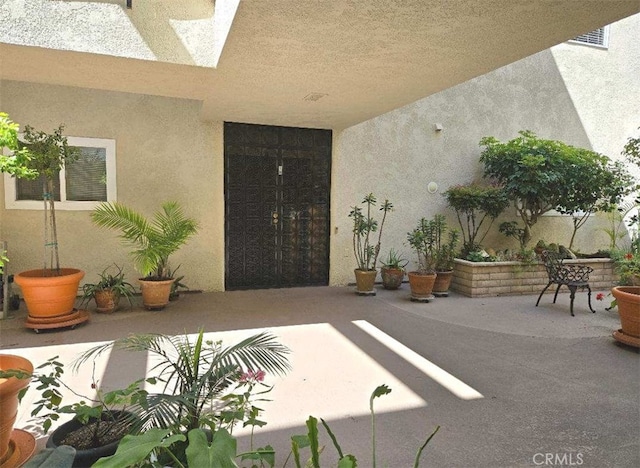 property entrance with a patio area and stucco siding
