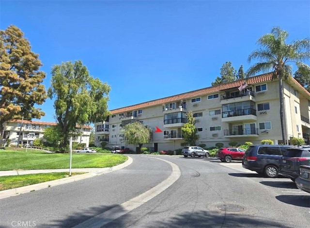 view of apartment building / complex with uncovered parking