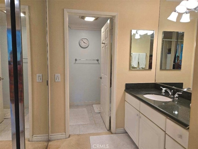bathroom with baseboards, vanity, and crown molding
