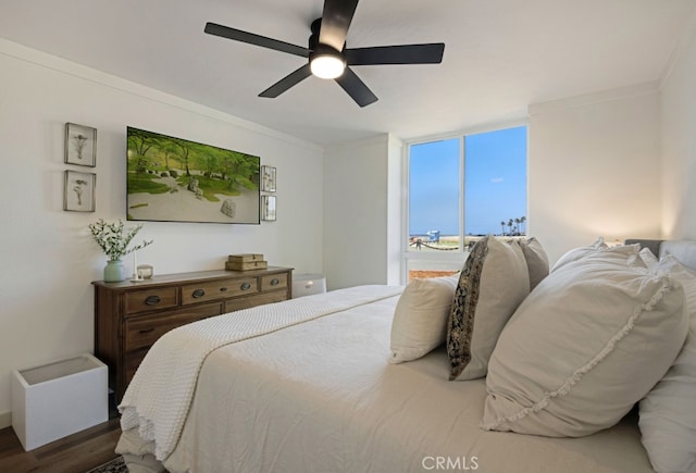 bedroom with wood finished floors, ornamental molding, and ceiling fan