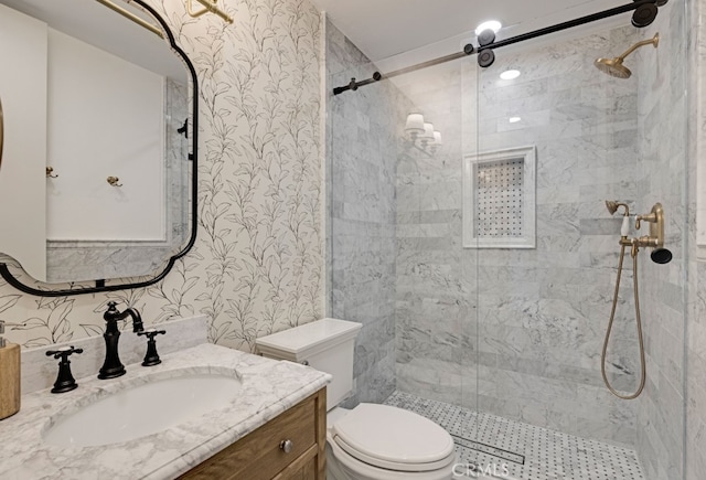 full bathroom with toilet, wallpapered walls, a stall shower, and vanity