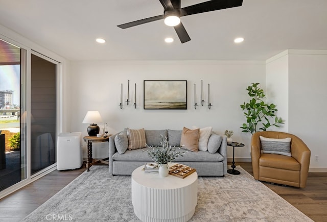 living area with wood finished floors, recessed lighting, a ceiling fan, and baseboards