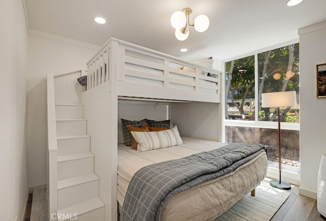 bedroom featuring wood finished floors, recessed lighting, and a wall of windows