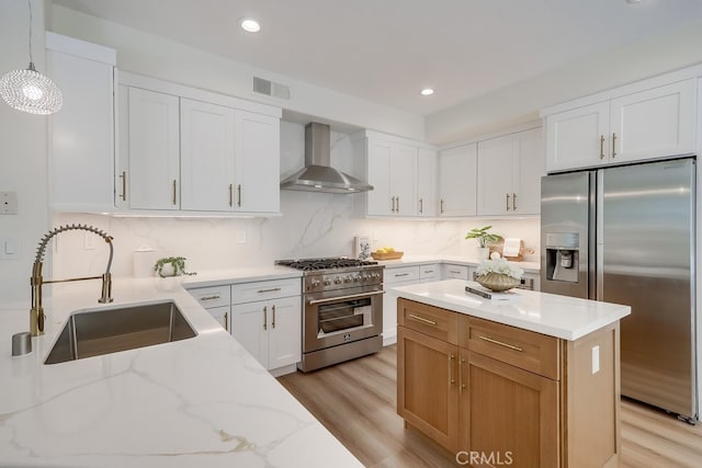 2115 Via Viejo, San Clemente, CA 92673 - kitchen featuring wall chimney exhaust hood, appliances with stainless steel finishes, light wood-type flooring, light stone countertops, and a sink