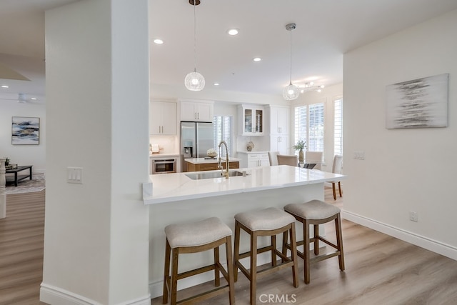 2115 Via Viejo, San Clemente, CA 92673 - kitchen with built in fridge, a kitchen breakfast bar, white cabinetry, recessed lighting, and light wood-type flooring