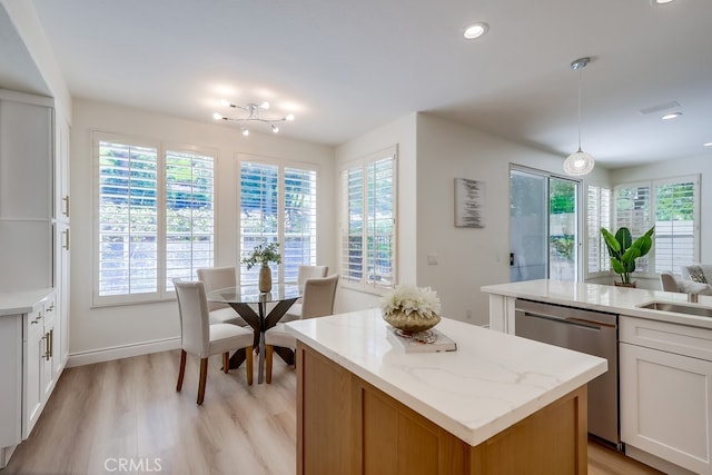 2115 Via Viejo, San Clemente, CA 92673 - kitchen with stainless steel dishwasher, a kitchen island, light wood-type flooring, white cabinets, and pendant lighting