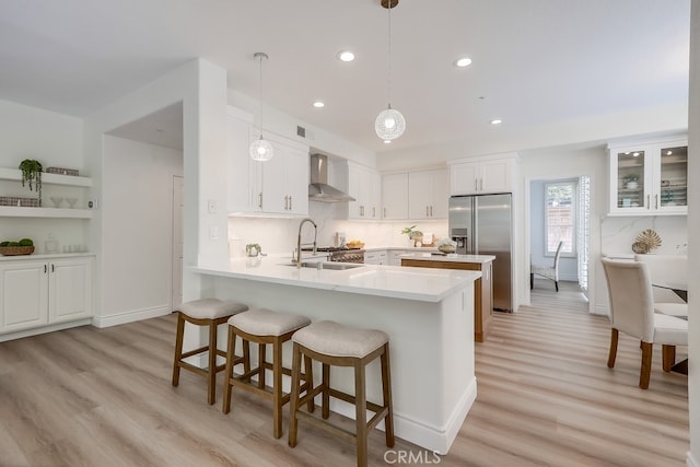 2115 Via Viejo, San Clemente, CA 92673 - kitchen featuring wall chimney exhaust hood, stainless steel fridge, a sink, a peninsula, and light wood-style flooring