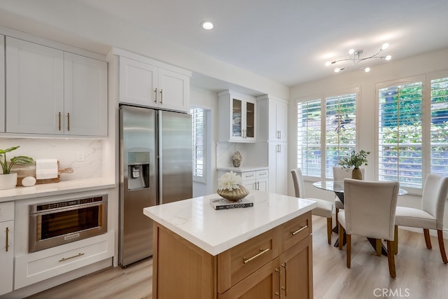 2115 Via Viejo, San Clemente, CA 92673 - kitchen with stainless steel appliances, light wood-type flooring, backsplash, white cabinetry, and glass insert cabinets