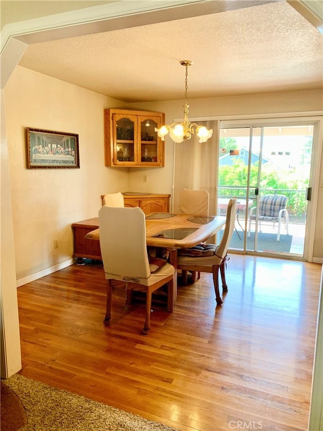 18427 Deer Hl, Hidden Valley Lake, CA 95467 - dining area with light wood-type flooring, a textured ceiling, and a chandelier