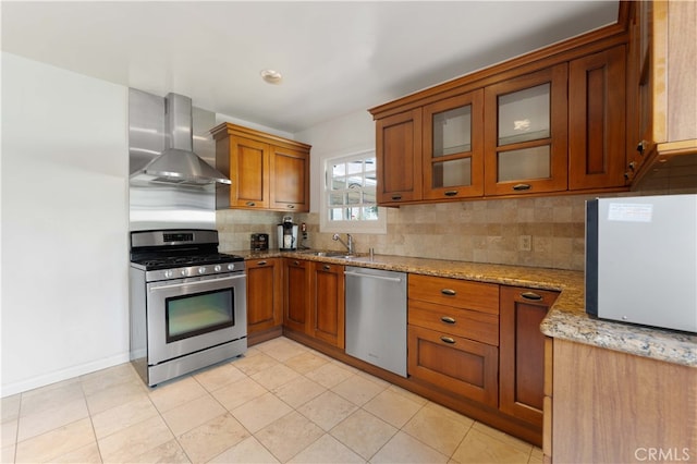 1194 Avoca Ave, Pasadena, CA 91105 - kitchen with stainless steel appliances, wall chimney exhaust hood, brown cabinetry, decorative backsplash, and light stone counters