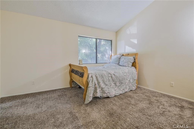 carpeted bedroom with vaulted ceiling and baseboards