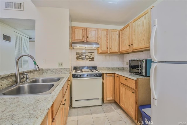 kitchen featuring white appliances, a sink, under cabinet range hood, decorative backsplash, and light tile patterned flooring