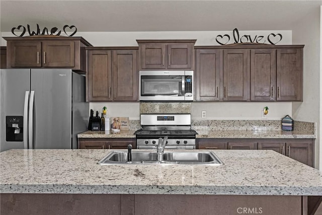 2289 Kyla Ct, San Bernardino, CA 92410 - kitchen with appliances with stainless steel finishes, a sink, light countertops, and dark brown cabinets